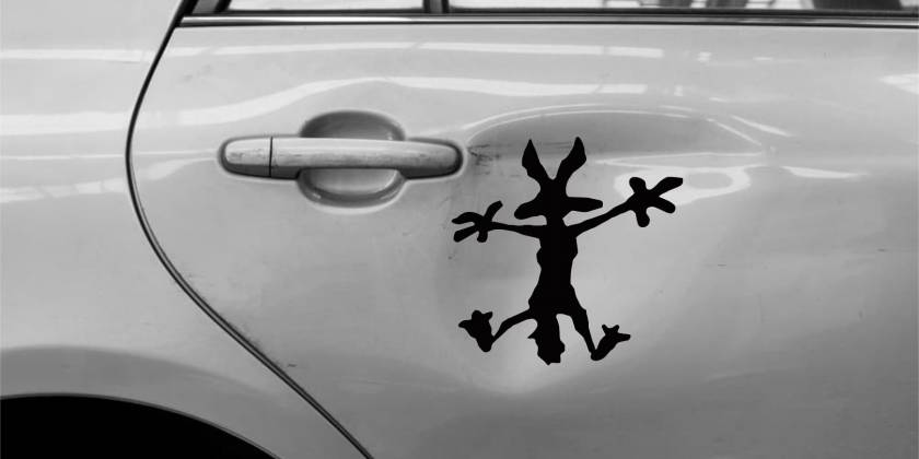 Наклейка койота на помятой двери автомобиля